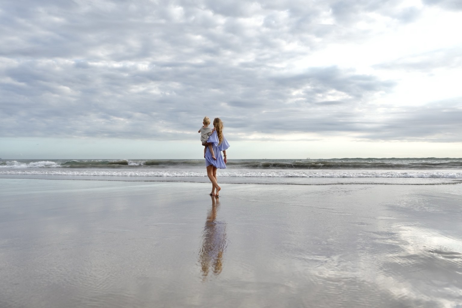 Charlene Rennit and Rumi walking together by the sea